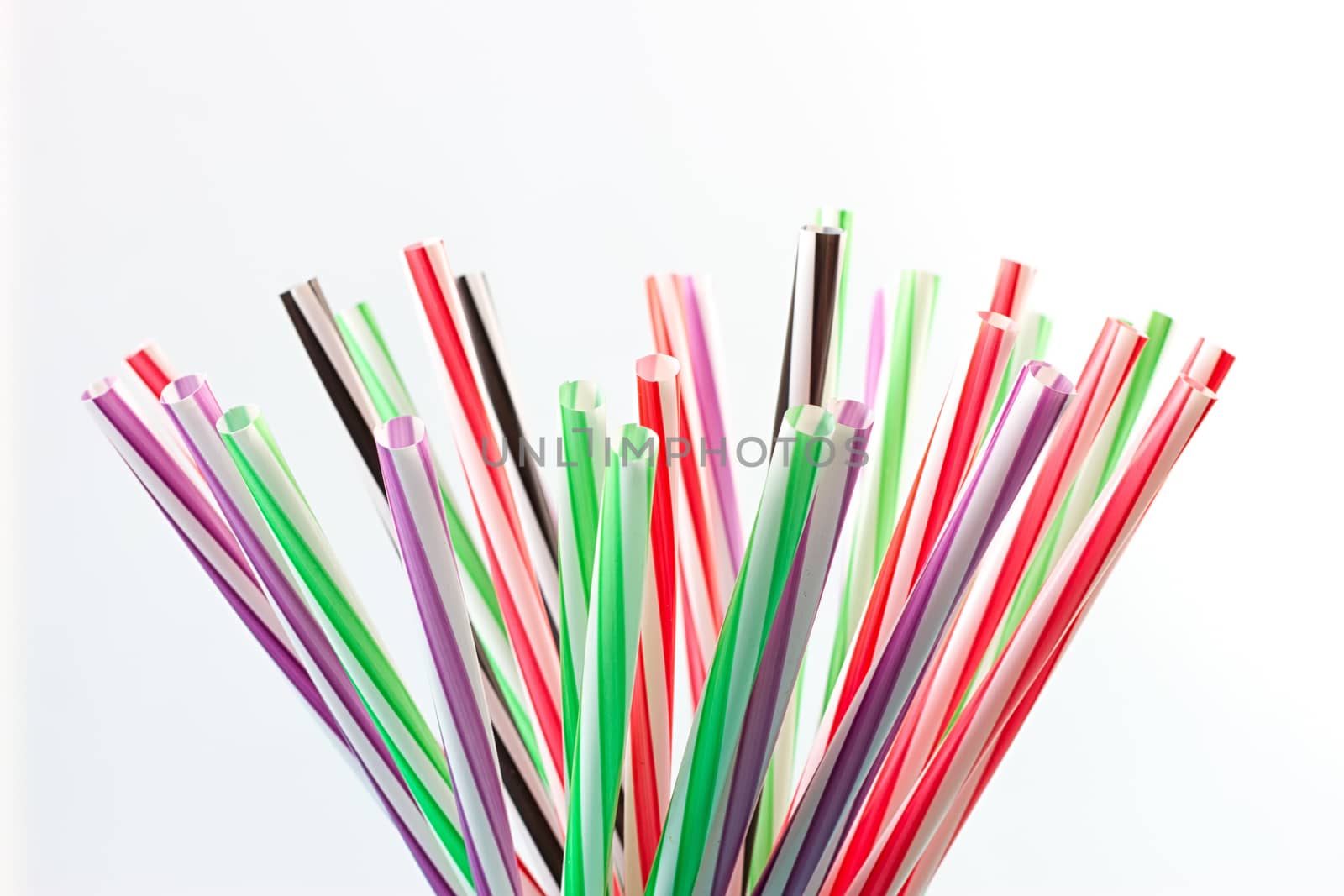 Colorful cocktail tubes in a glass cup