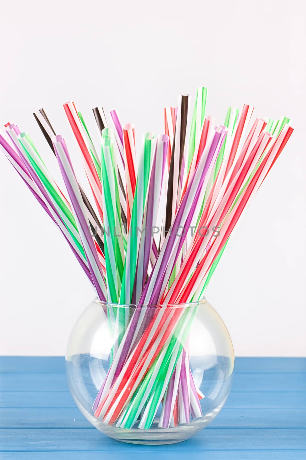 Colorful cocktail tubes in a glass cup