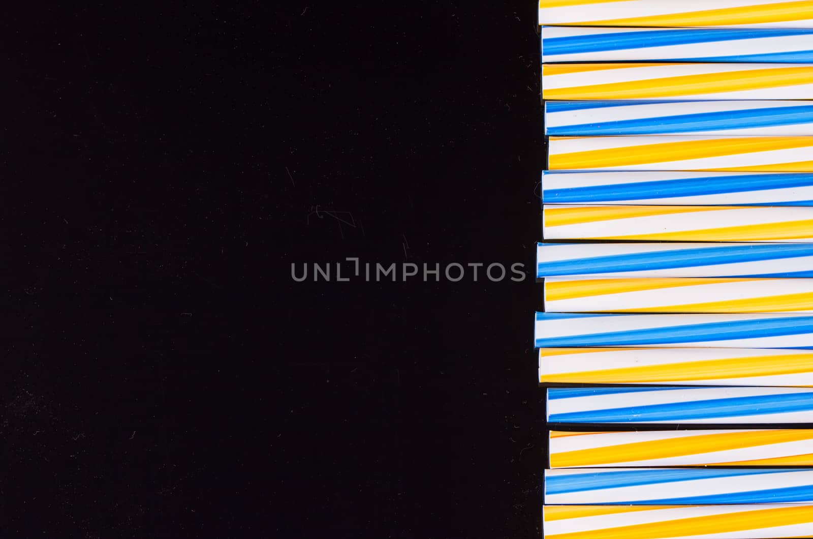 cocktail colorful plastic tube on a black background