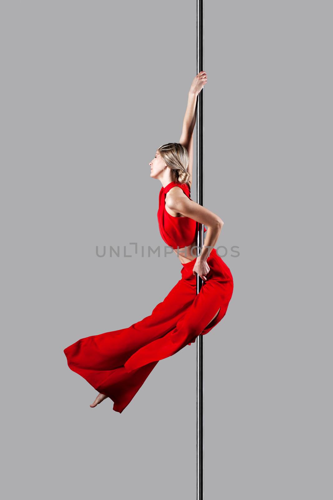 pole dance girl in elegant red outfit posing against gray background