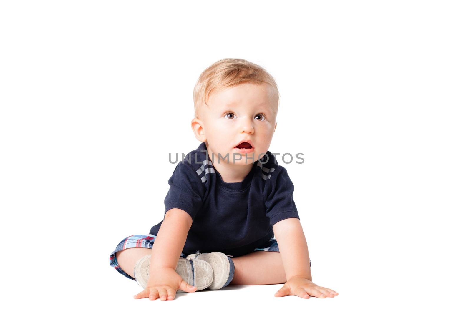 happy baby boy sitting on the floor, isolated on white