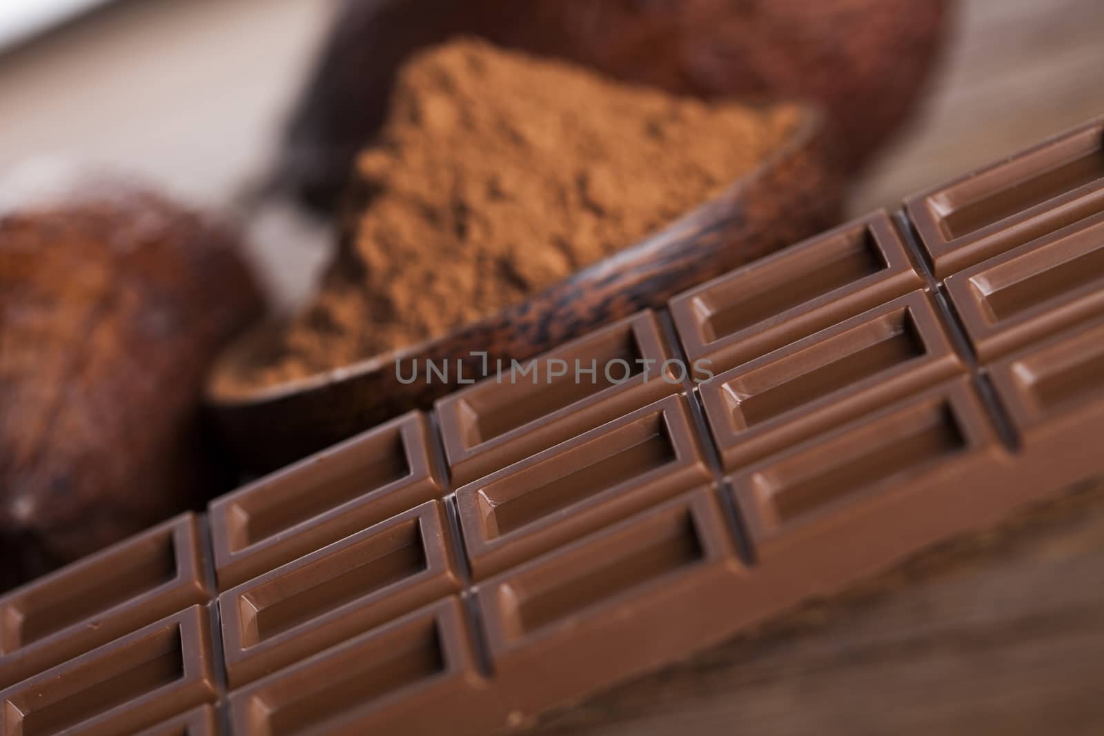 Chocolate bar, candy sweet, cacao beans and powder on wooden bac by JanPietruszka