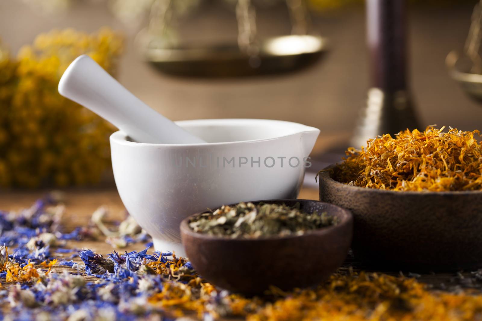 Herbs, berries and flowers with mortar, on wooden table backgrou by JanPietruszka