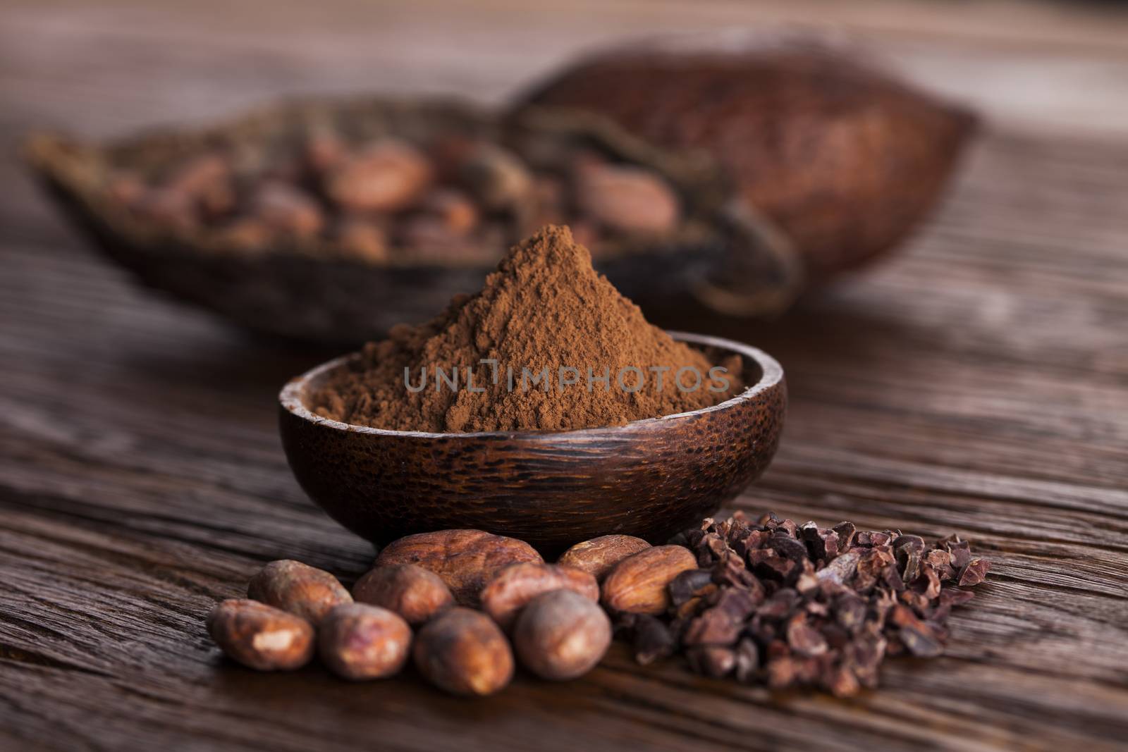 Cocoa beans in the dry cocoa pod fruit on wooden background by JanPietruszka