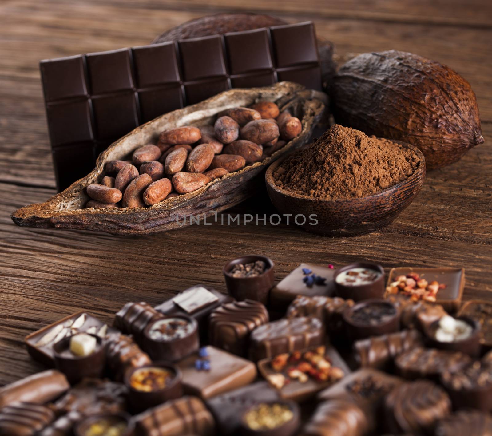 Chocolate bars and pralines on wooden background by JanPietruszka