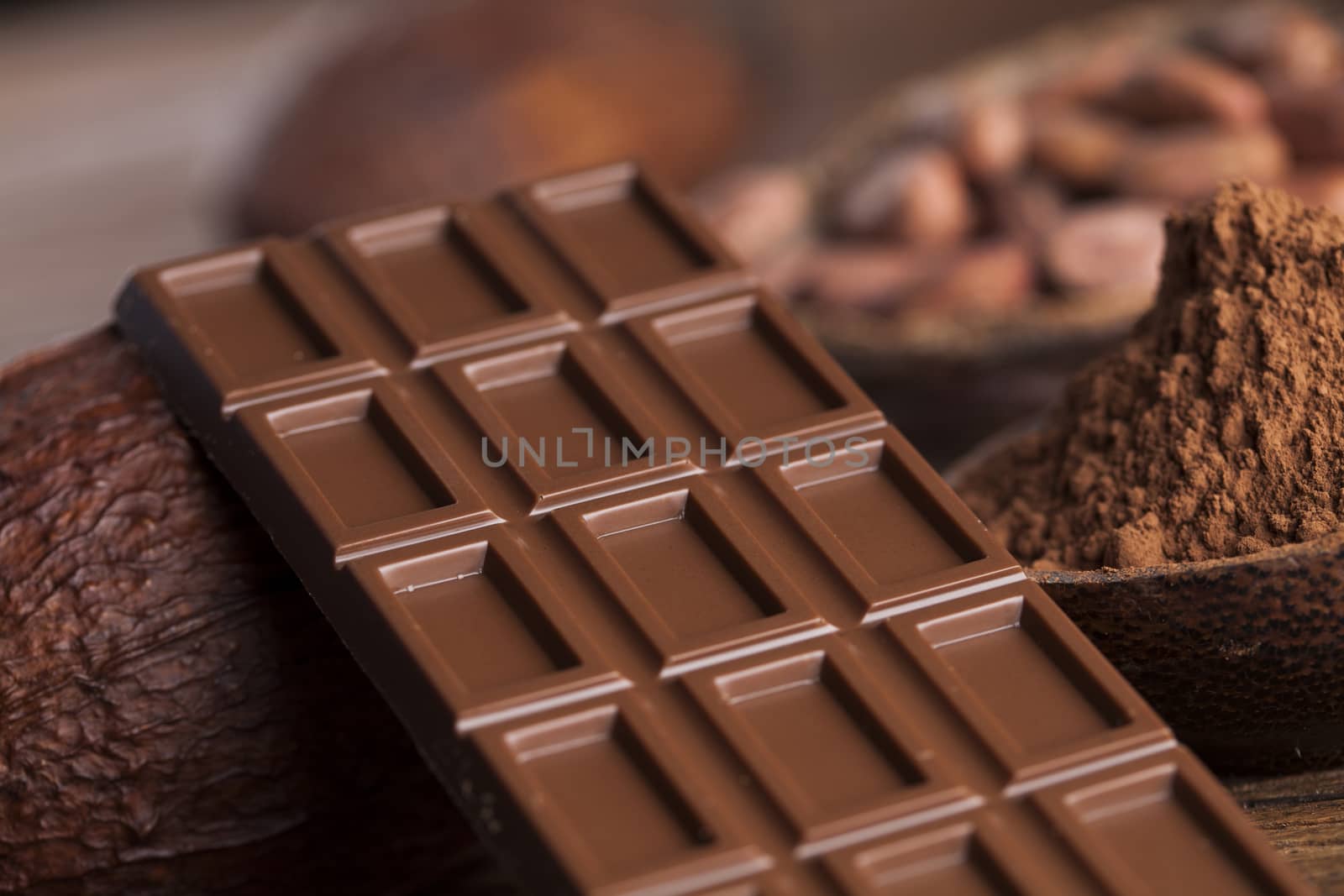 Dark homemade chocolate and cocoa pod on wooden