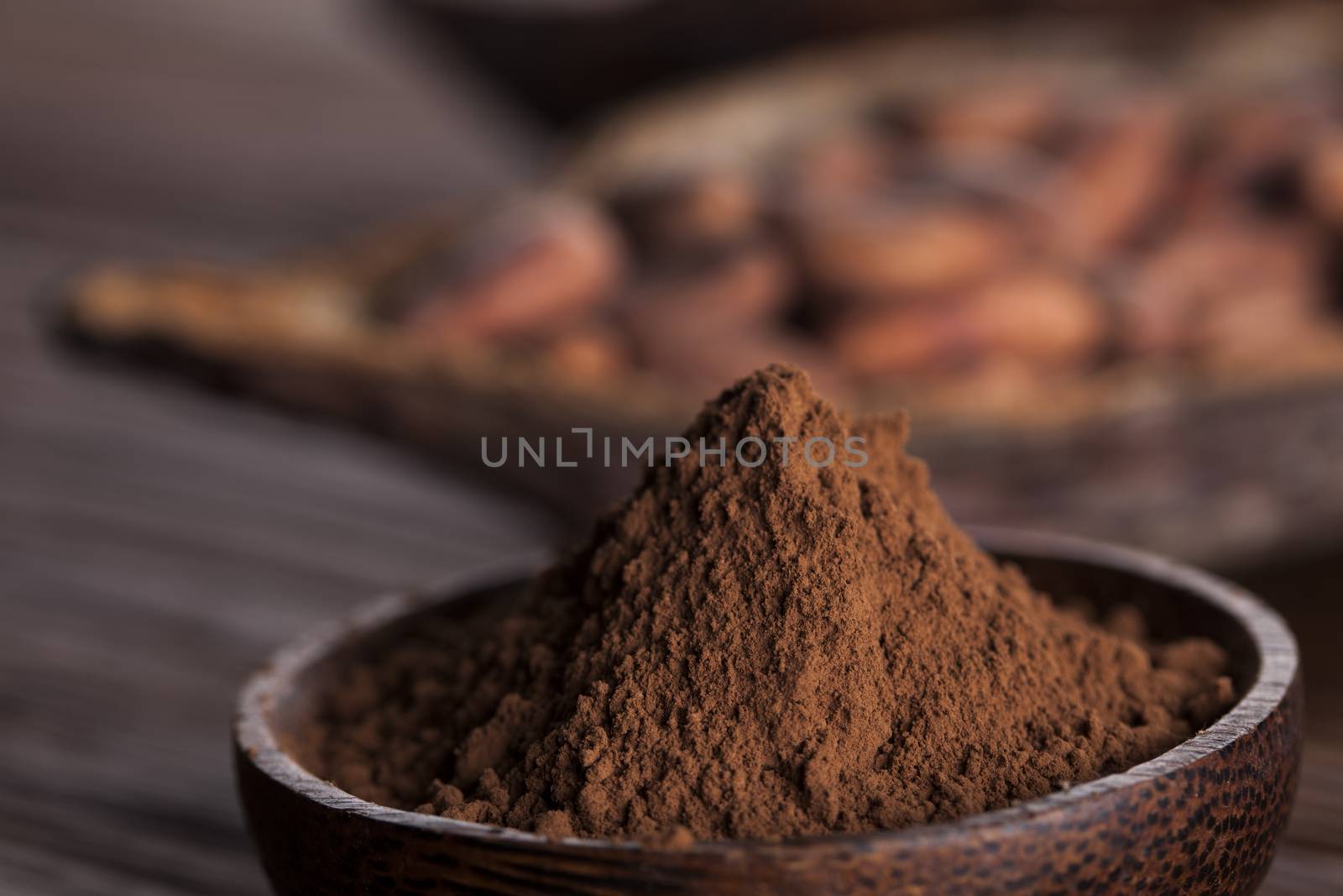 Cocoa beans in the dry cocoa pod fruit on wooden background by JanPietruszka