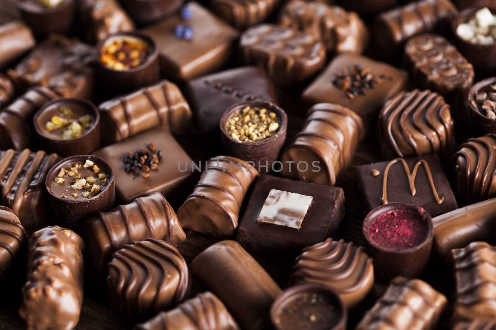 Chocolate bars and pralines on wooden background