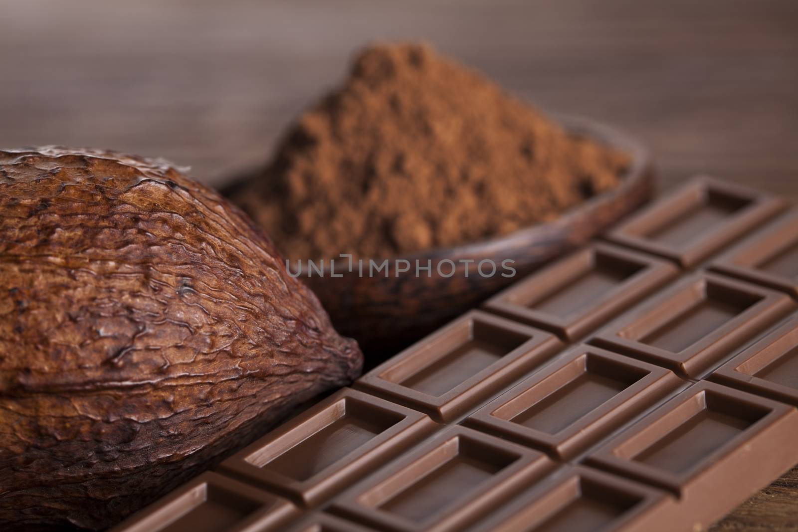 Aromatic cocoa and chocolate on wooden background