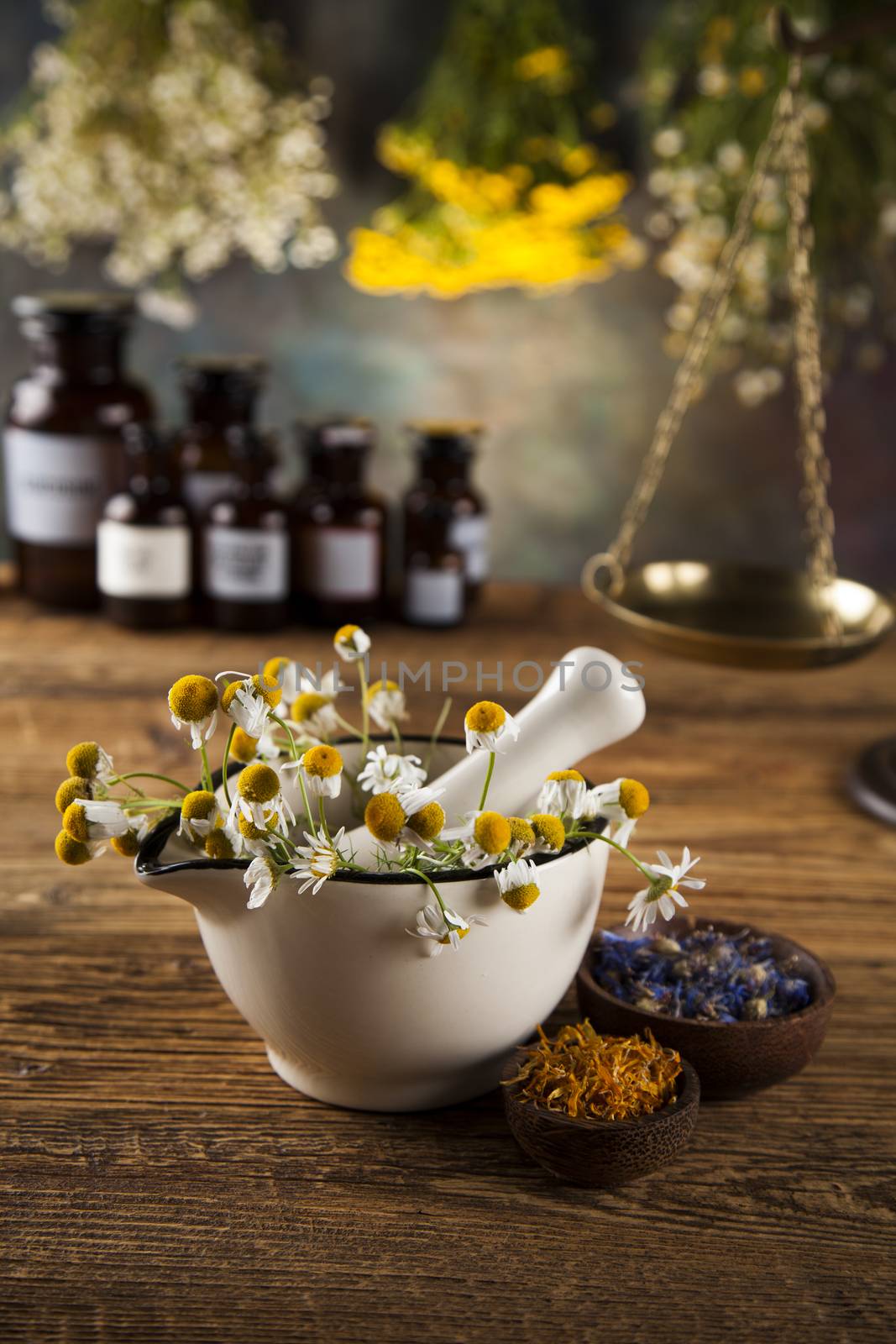 Assorted natural medical herbs and mortar on wooden table backgr by JanPietruszka