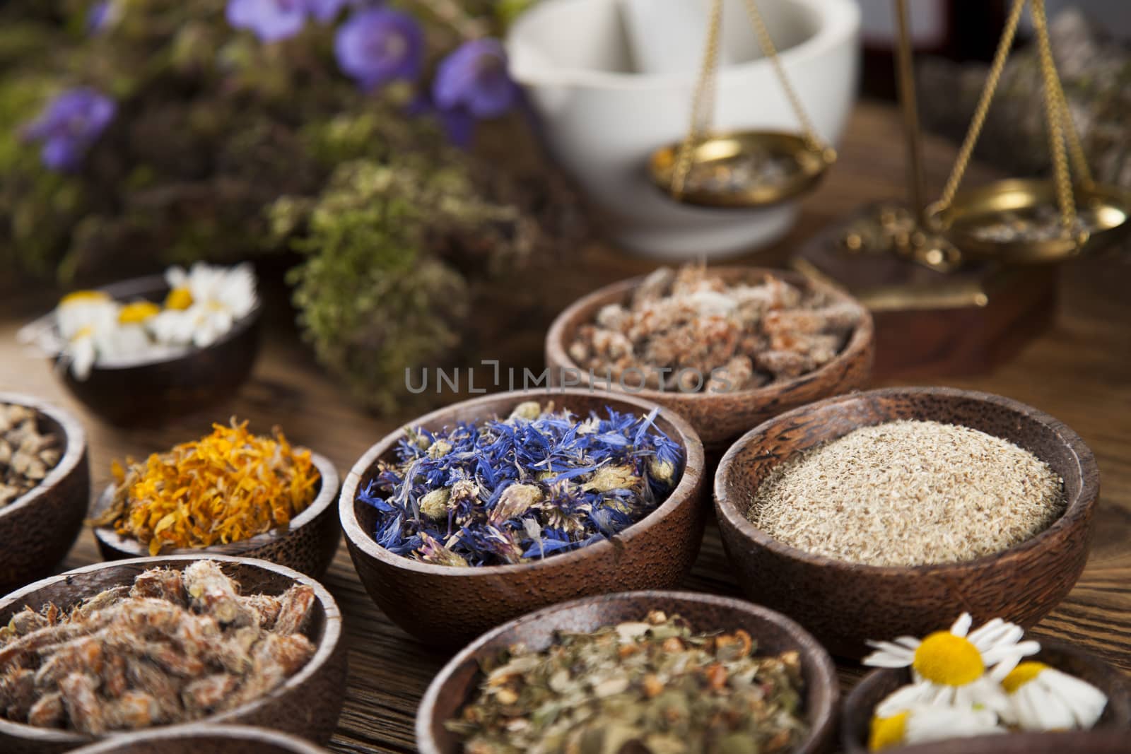 Herbs, berries and flowers with mortar, on wooden table backgrou by JanPietruszka