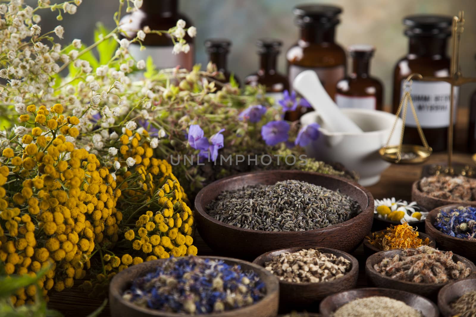 Herbs, berries and flowers with mortar, on wooden table backgrou by JanPietruszka