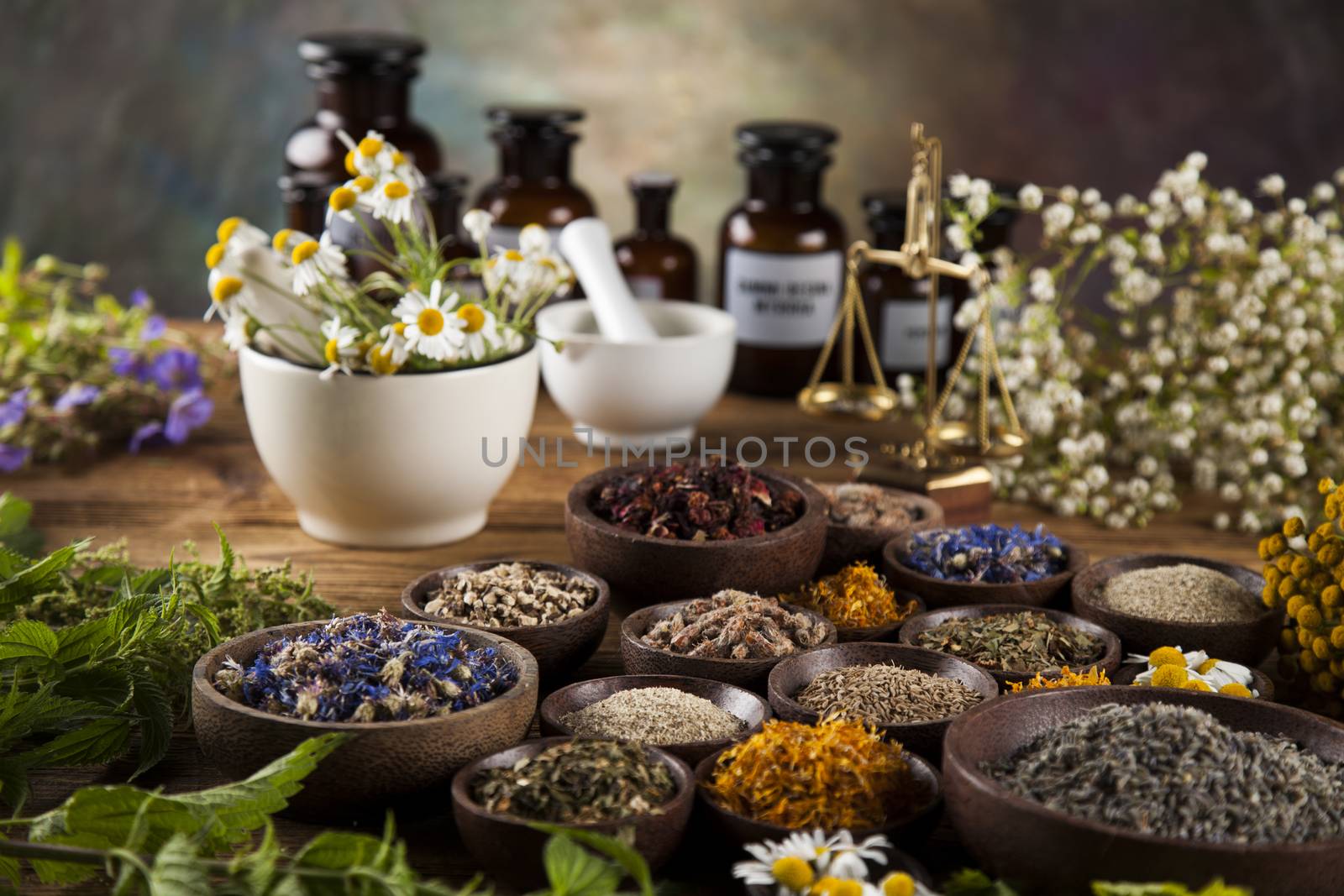 Alternative medicine, dried herbs and mortar on wooden desk back by JanPietruszka