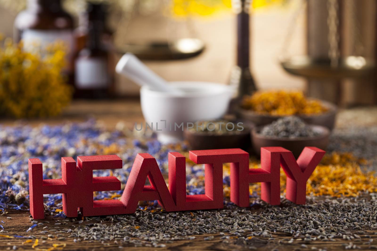 Healthy herbs on wooden table, mortar and herbal medicine  by JanPietruszka