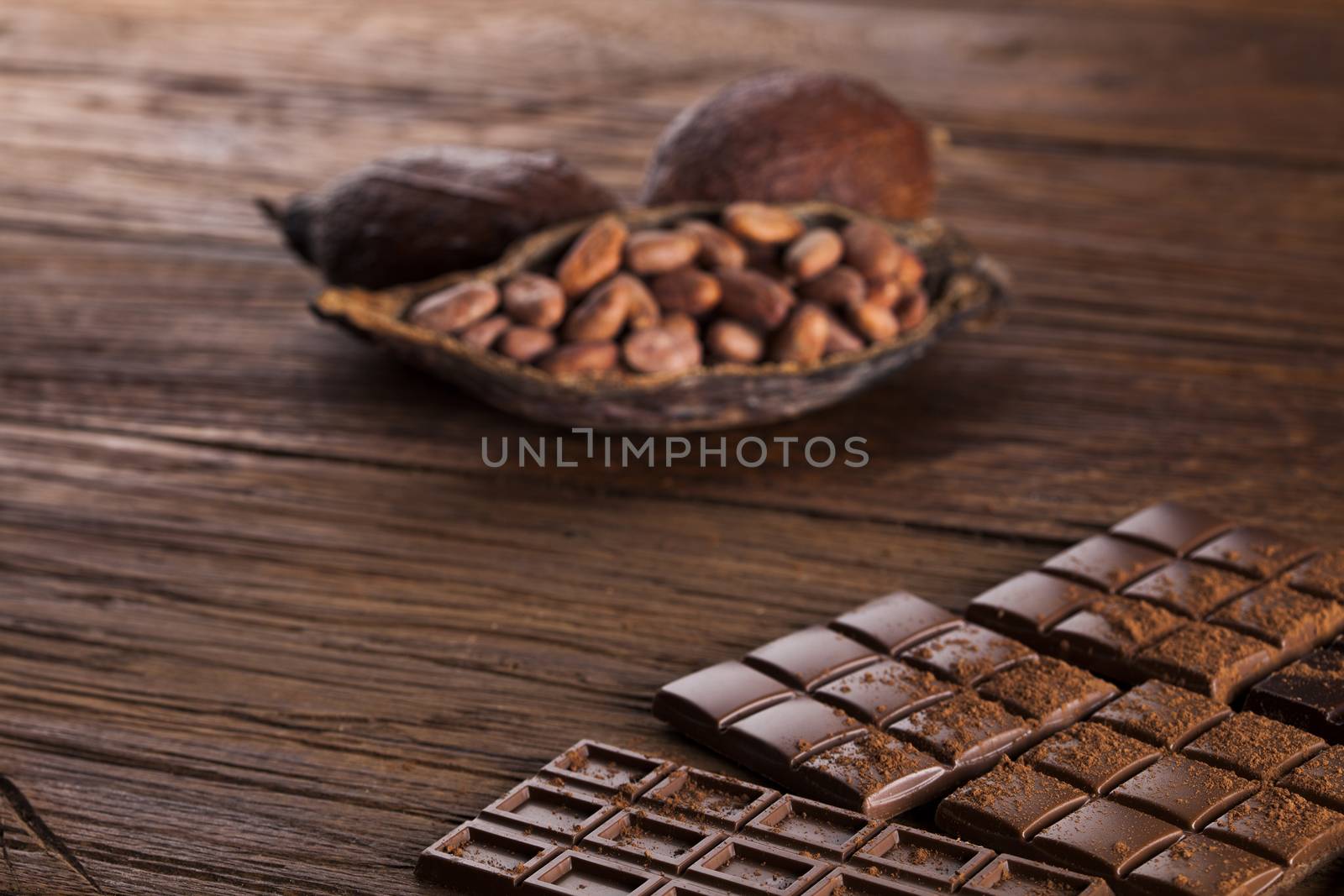 Dark homemade chocolate bars and cocoa pod on wooden  by JanPietruszka
