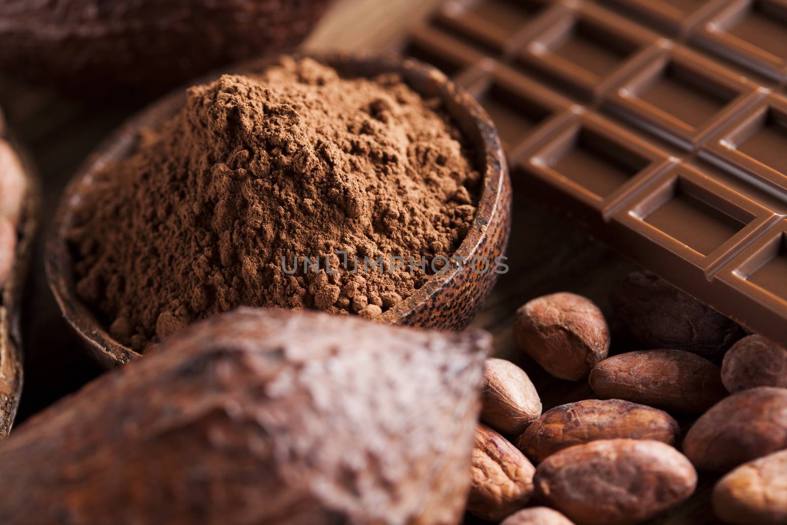 Chocolate bar, candy sweet, cacao beans and powder on wooden bac by JanPietruszka