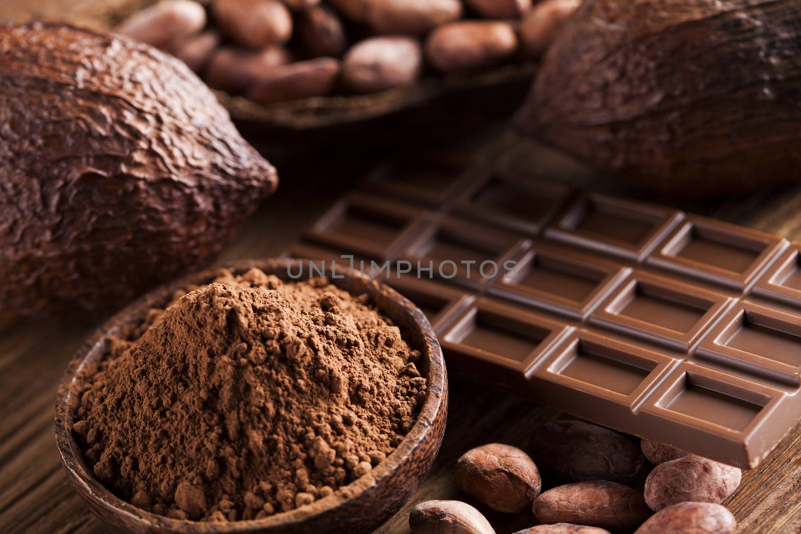 Chocolate bar, candy sweet, cacao beans and powder on wooden bac by JanPietruszka