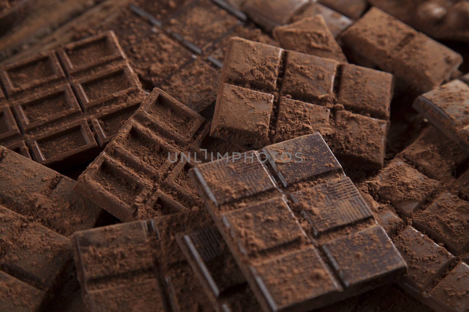 Dark homemade chocolate bars and cocoa pod on wooden