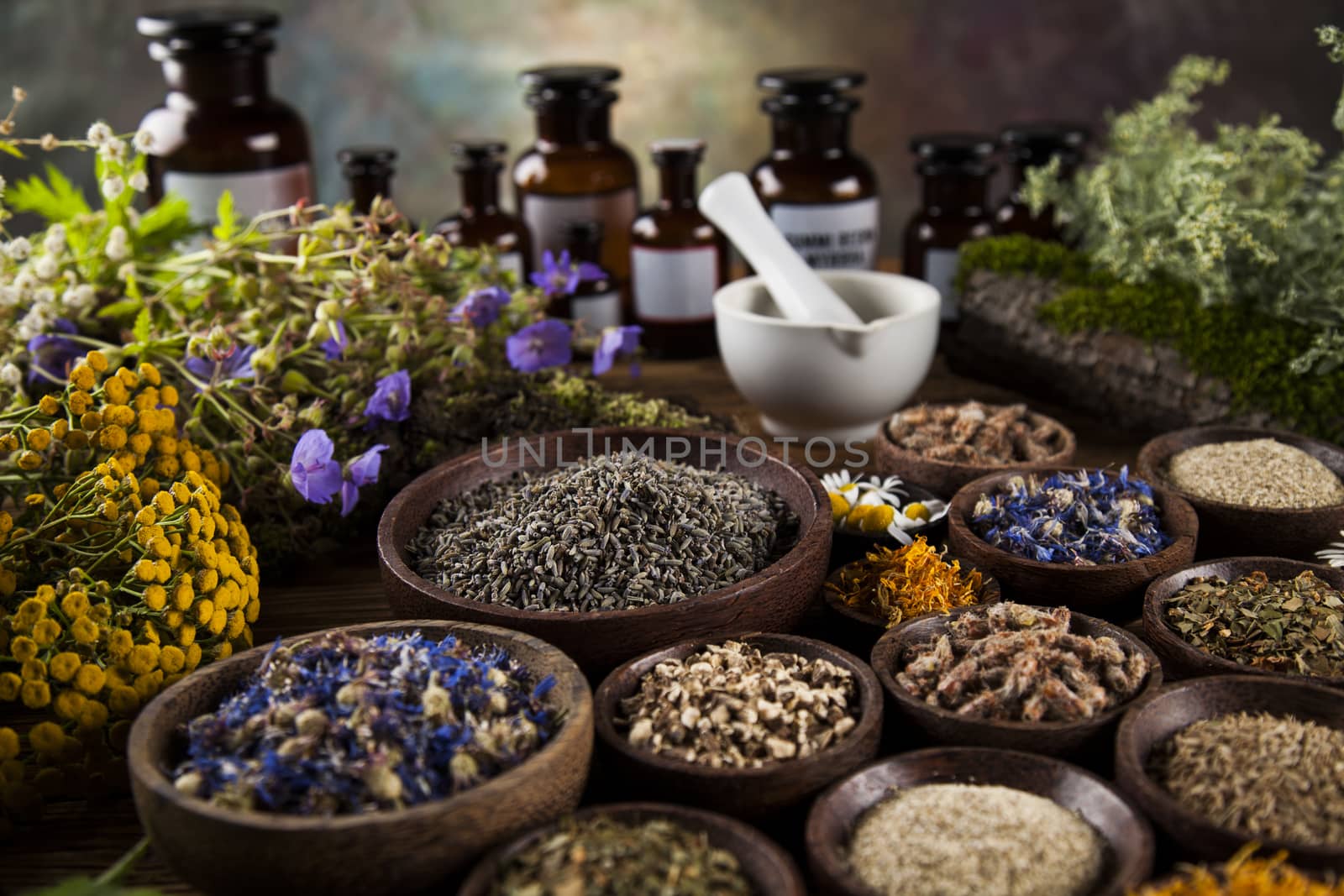 Herbs, berries and flowers with mortar, on wooden table backgrou by JanPietruszka