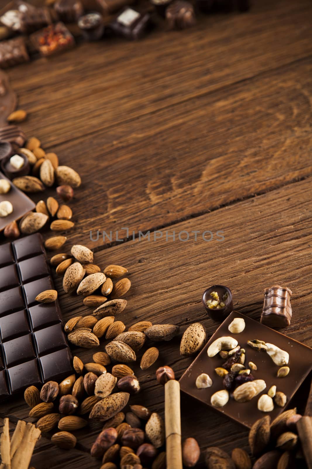 Chocolate bars and pralines on wooden background