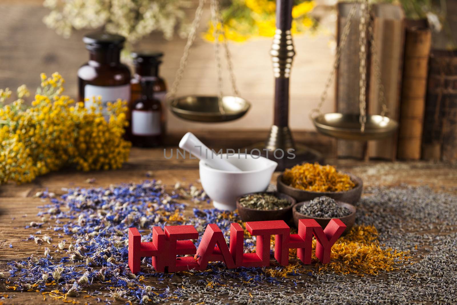 Healthy herbs on wooden table, mortar and herbal medicine  by JanPietruszka