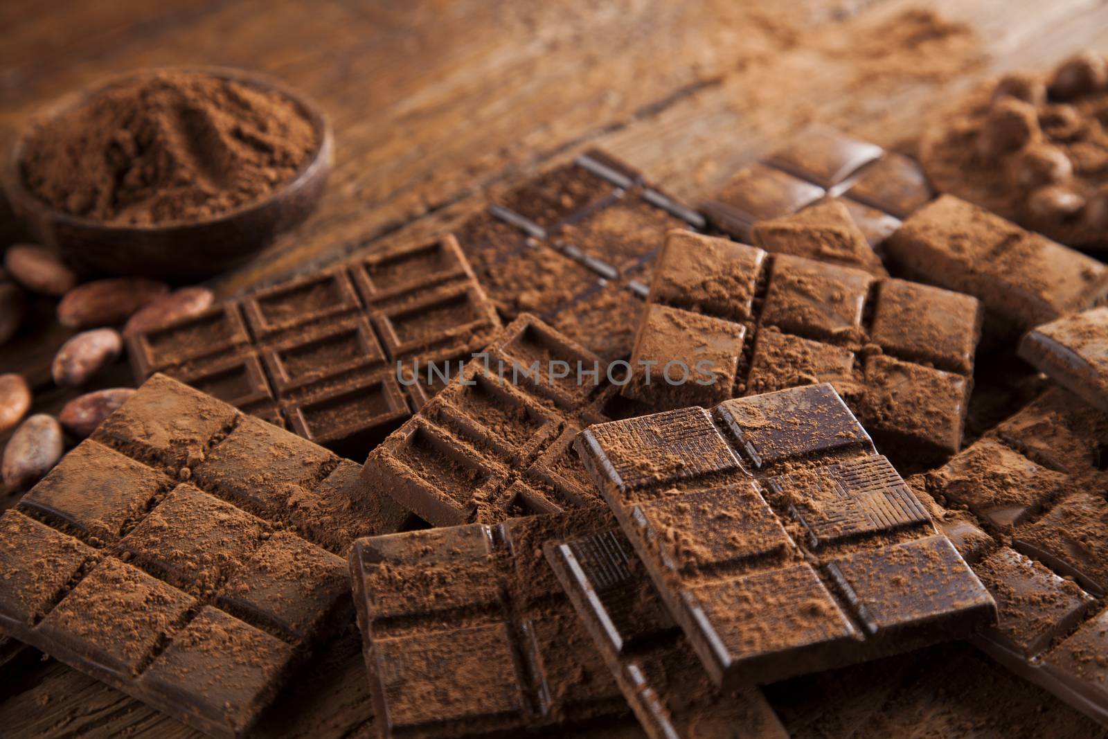 Dark homemade chocolate bars and cocoa pod on wooden