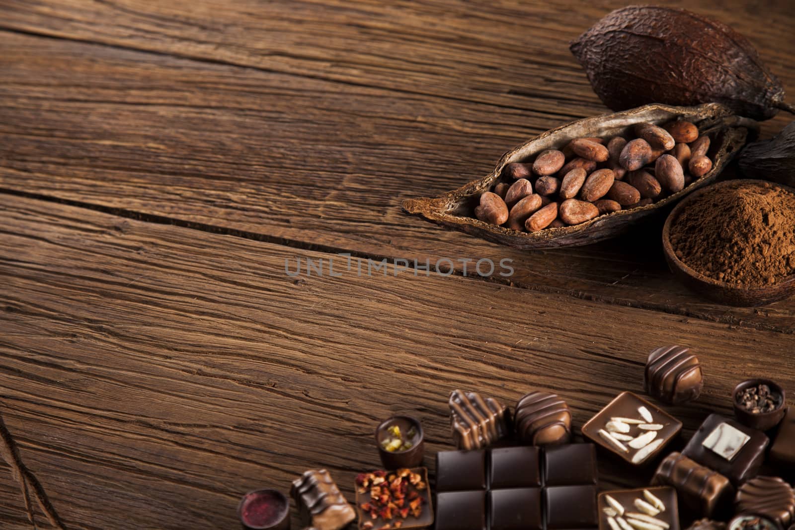 Chocolate bars and pralines on wooden background