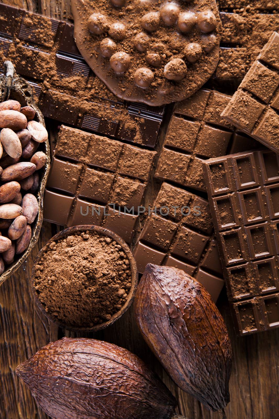 Dark homemade chocolate bars and cocoa pod on wooden