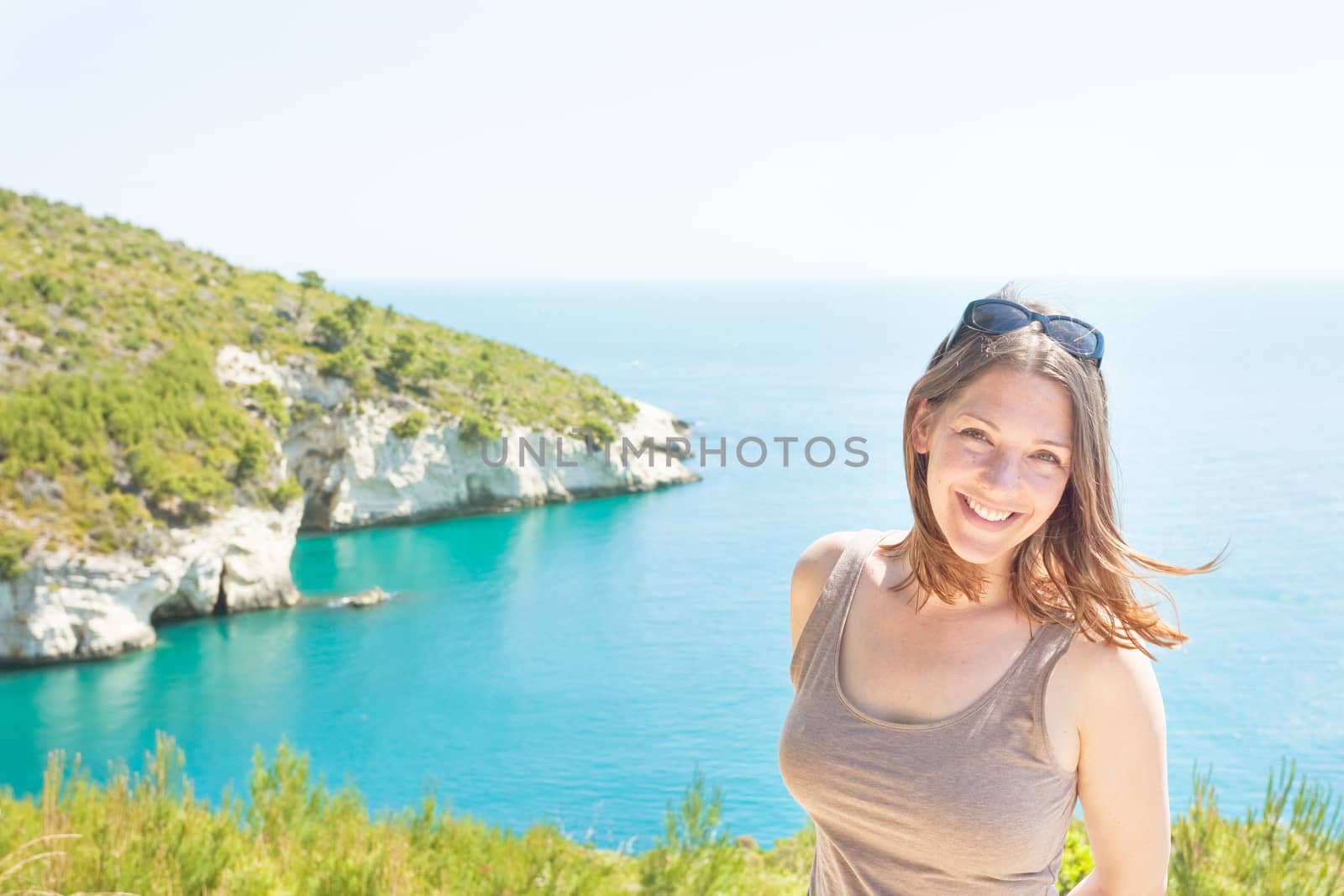 Apulia, Italy - Portrait of a smiling woman at Grotta della Camp by tagstiles.com
