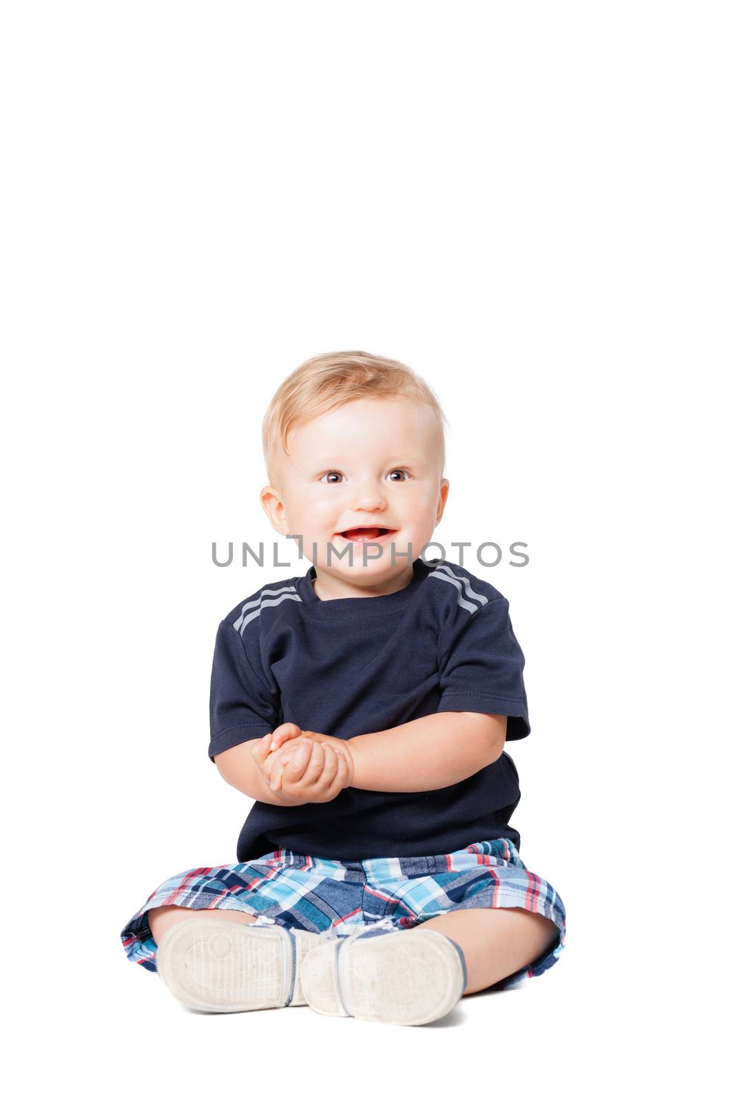 happy baby boy sitting on the floor, isolated on white