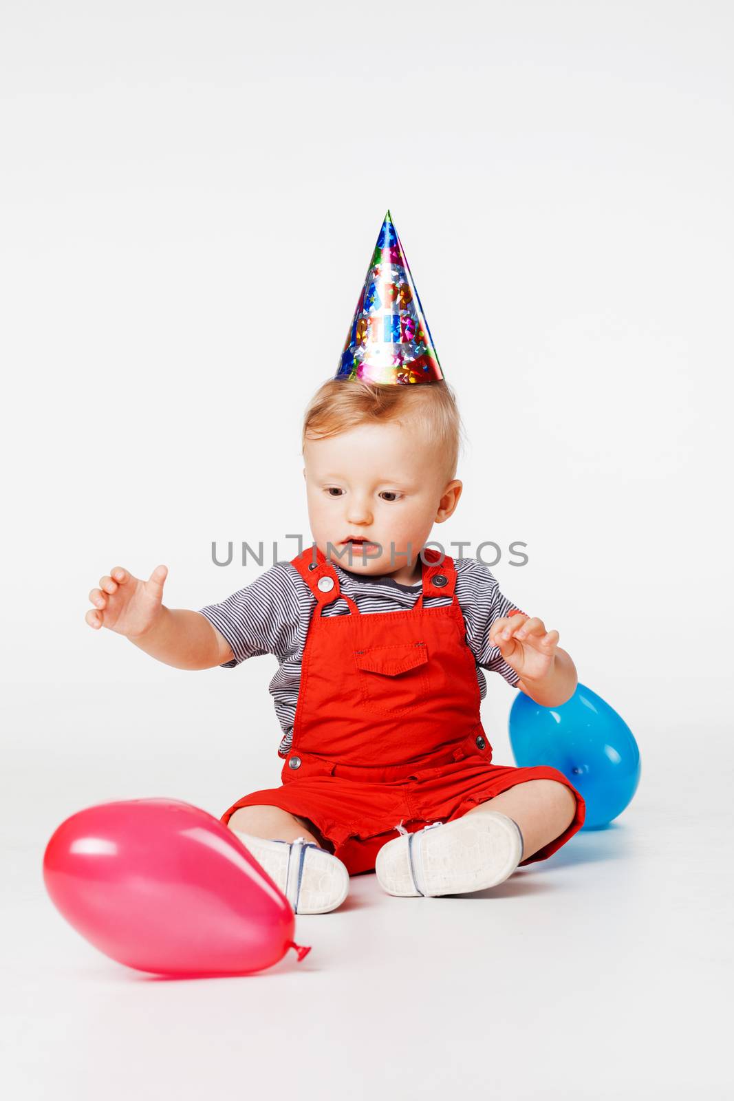 baby boy with birthday hat and balloons