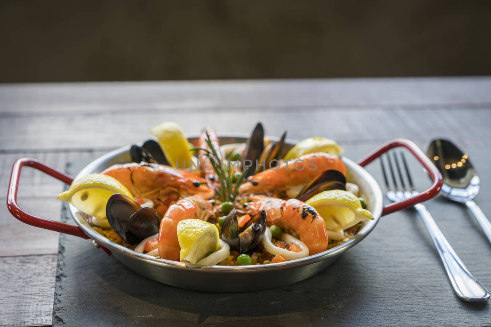 Paella with seafood vegetables and saffron served in the traditional pan