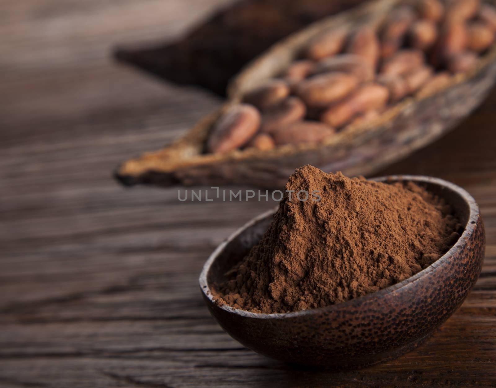 Cocoa beans in the dry cocoa pod fruit on wooden background by JanPietruszka