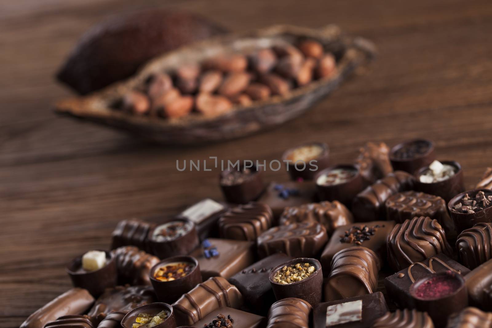 Chocolate bars and pralines on wooden background