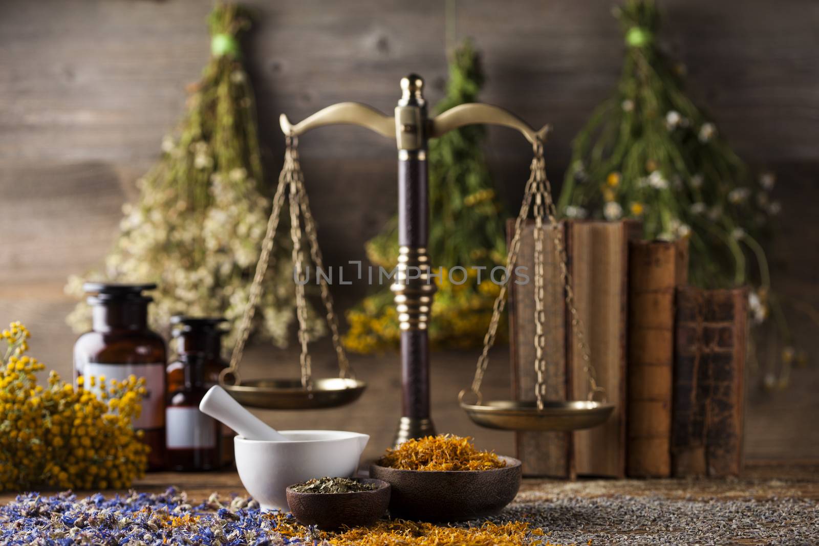 Herbs, berries and flowers with mortar, on wooden table backgrou by JanPietruszka