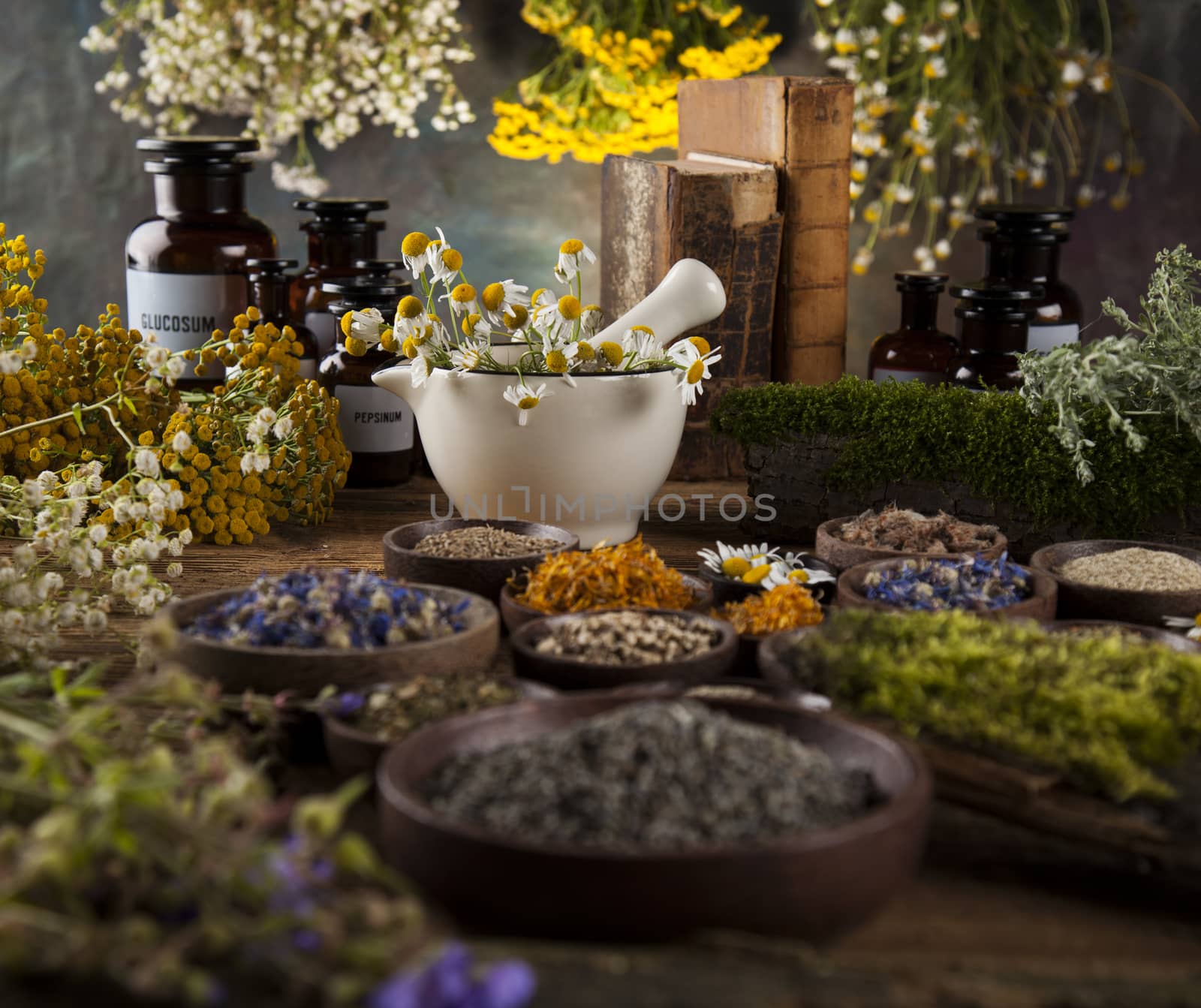 Herbs, berries and flowers with mortar, on wooden table background