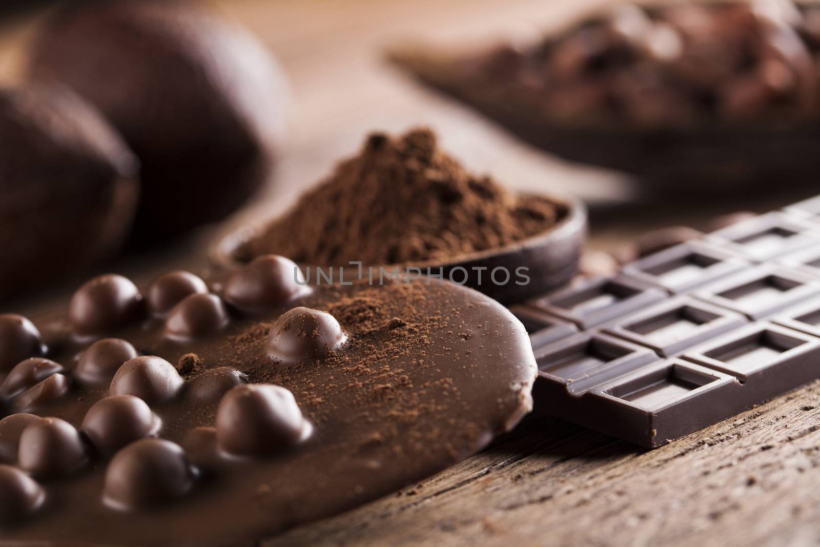 Aromatic cocoa and chocolate on wooden background