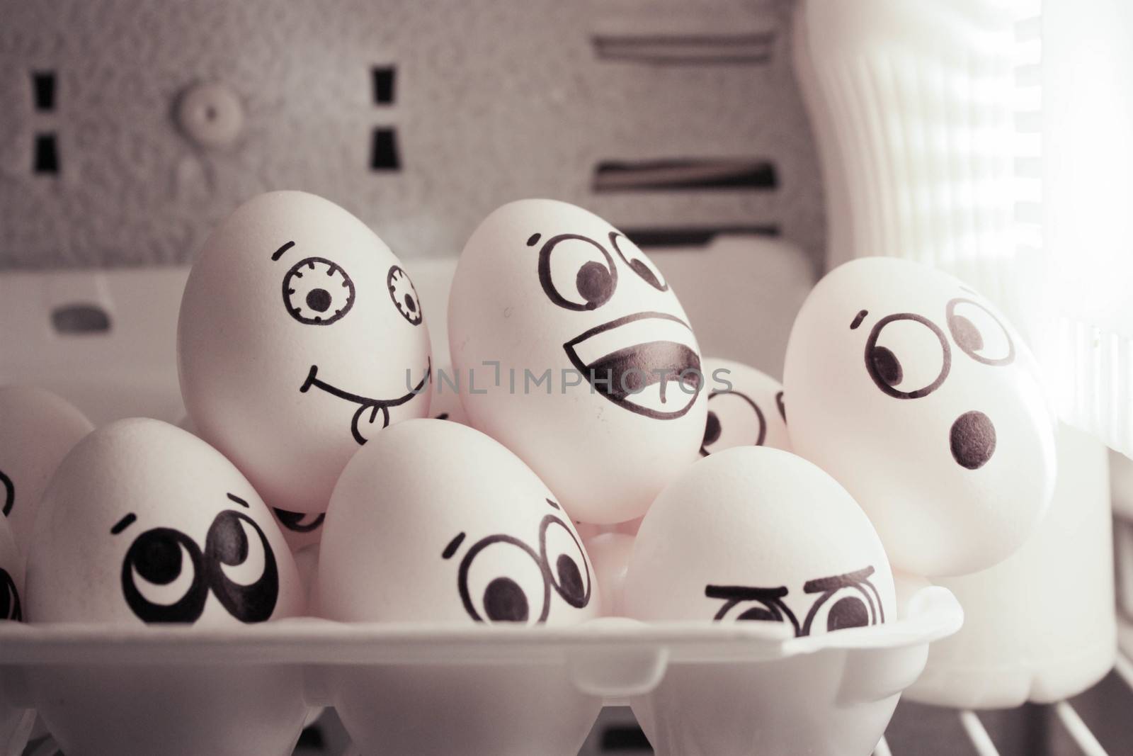 Concept of enlightenment. Face eggs are funny in the fridge. Photo for your design. A group of eggs looks at the light.