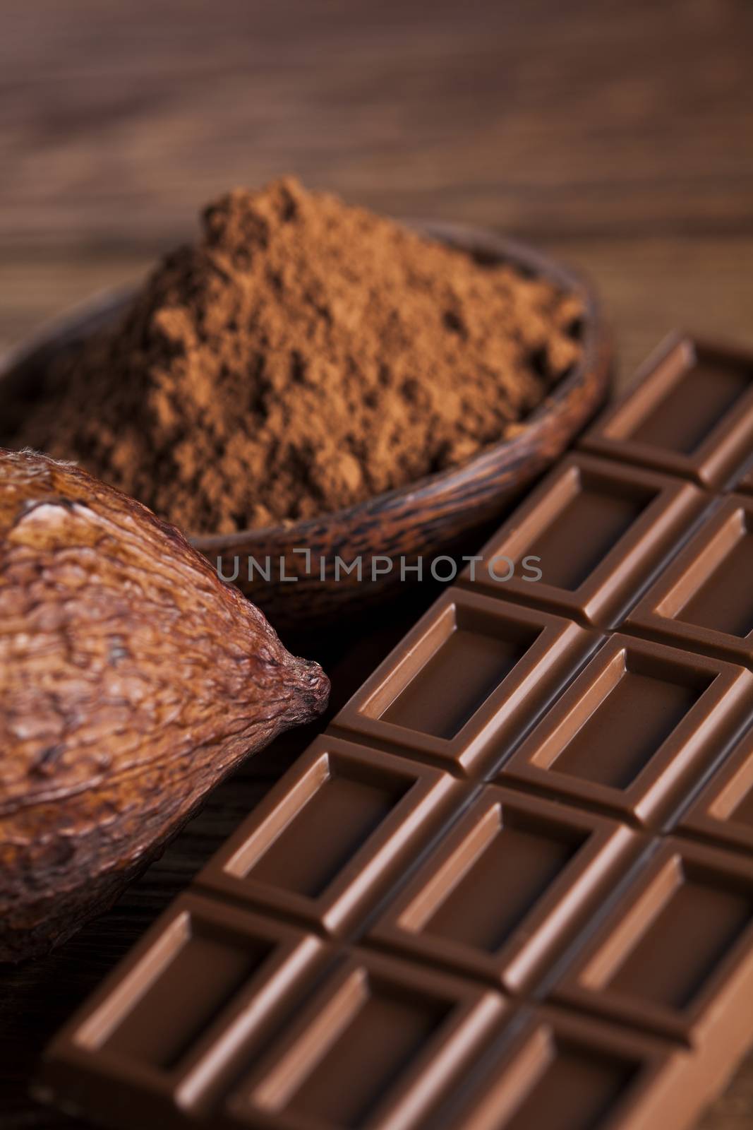 Aromatic cocoa and chocolate on wooden background