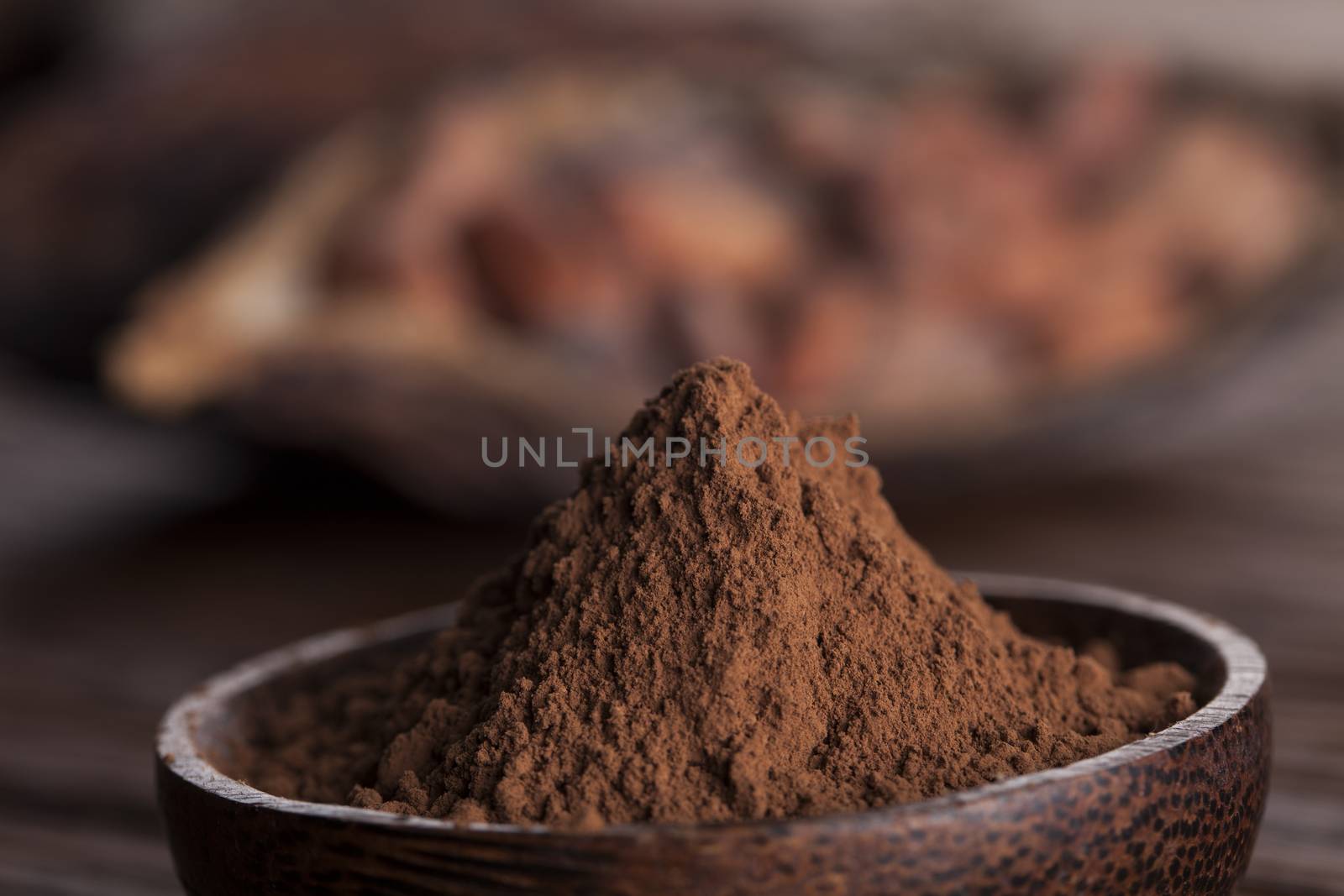 Cocoa beans in the dry cocoa pod fruit on wooden background