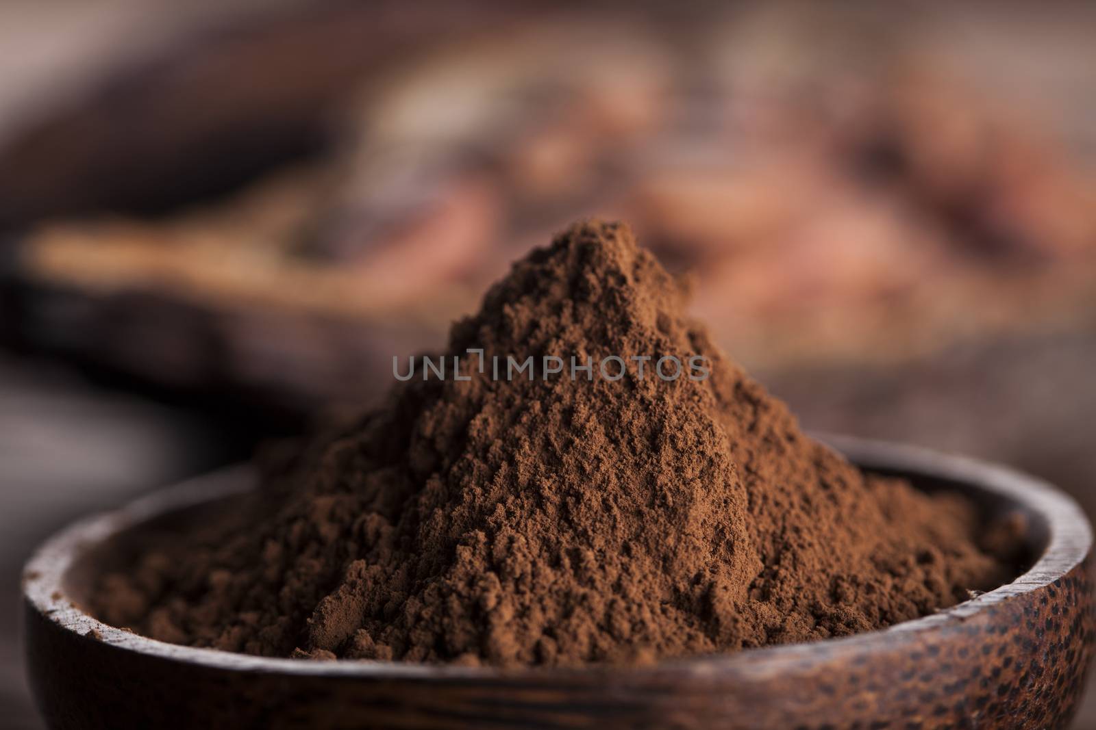 Cocoa beans in the dry cocoa pod fruit on wooden background