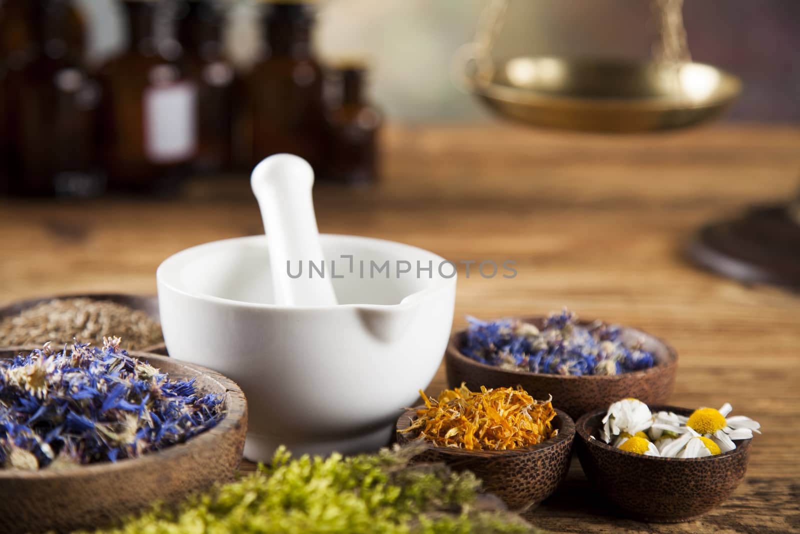 Assorted natural medical herbs and mortar on wooden table backgr by JanPietruszka