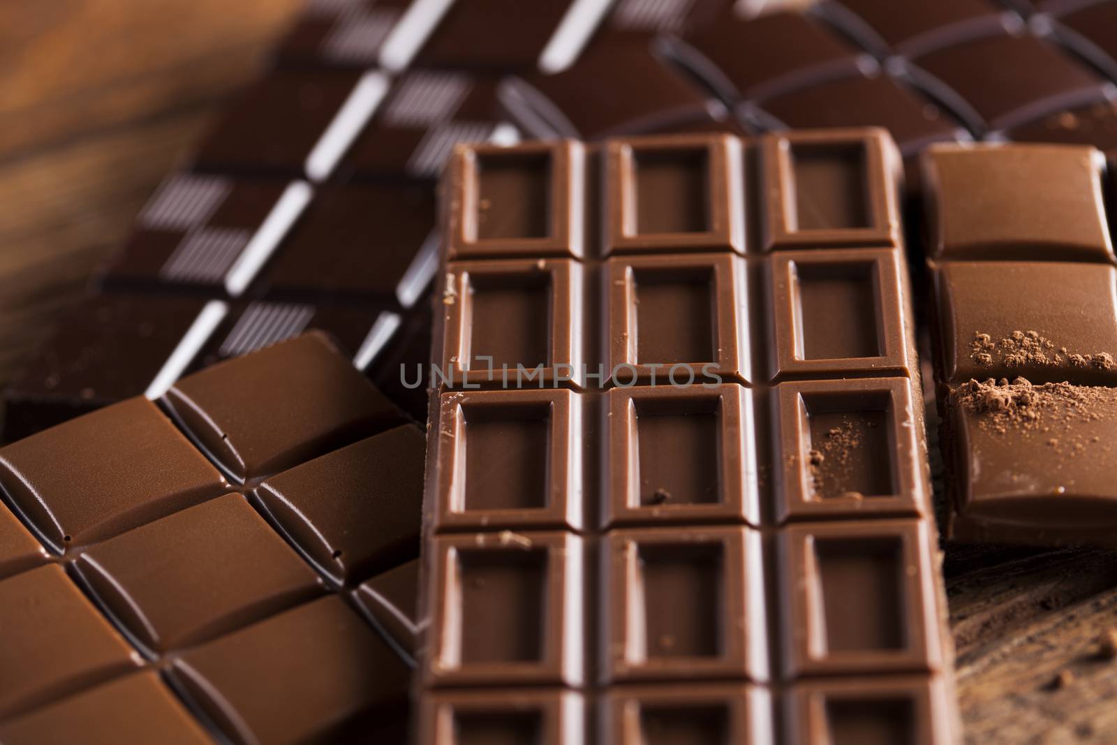 Milk and dark chocolate on a wooden table