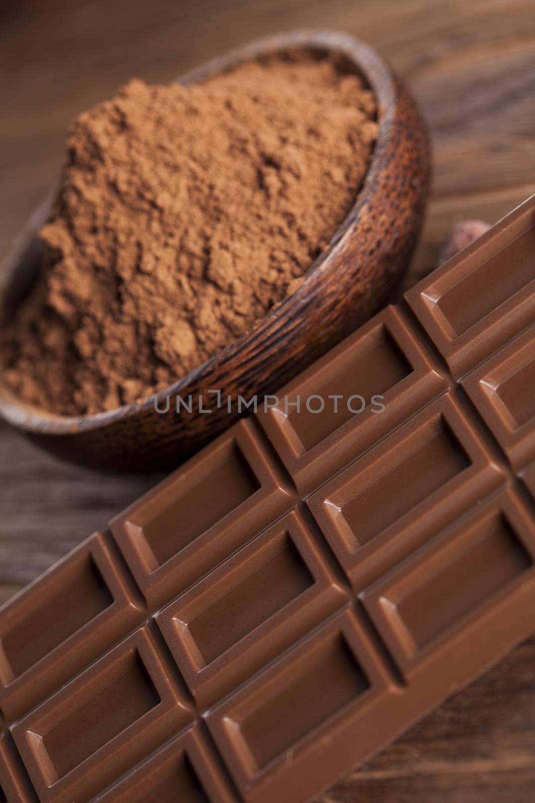 Chocolate bar, candy sweet, cacao beans and powder on wooden bac by JanPietruszka