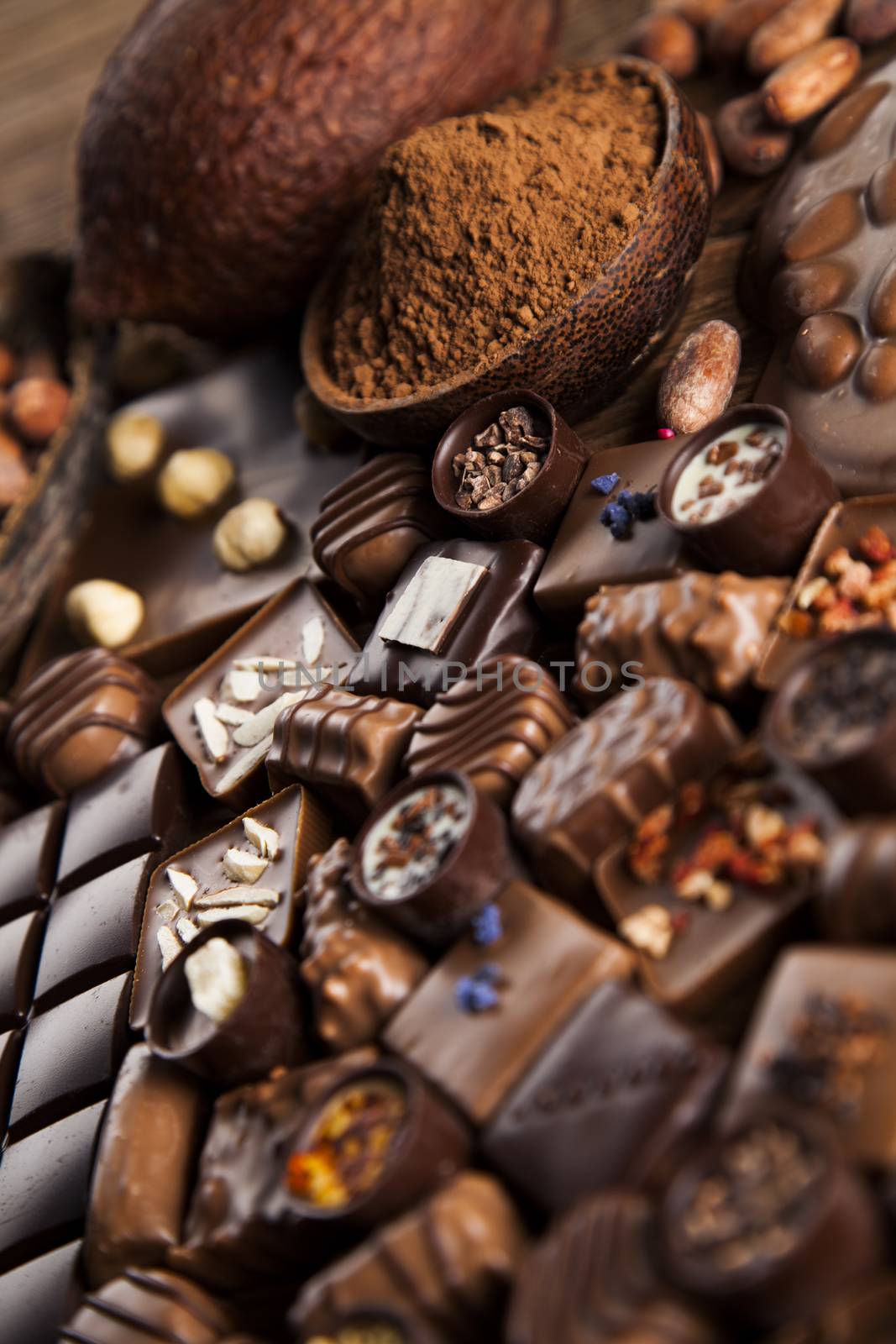 Chocolate bars and pralines on wooden background by JanPietruszka