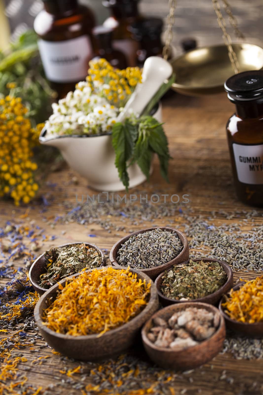 Herbs, berries and flowers with mortar, on wooden table backgrou by JanPietruszka