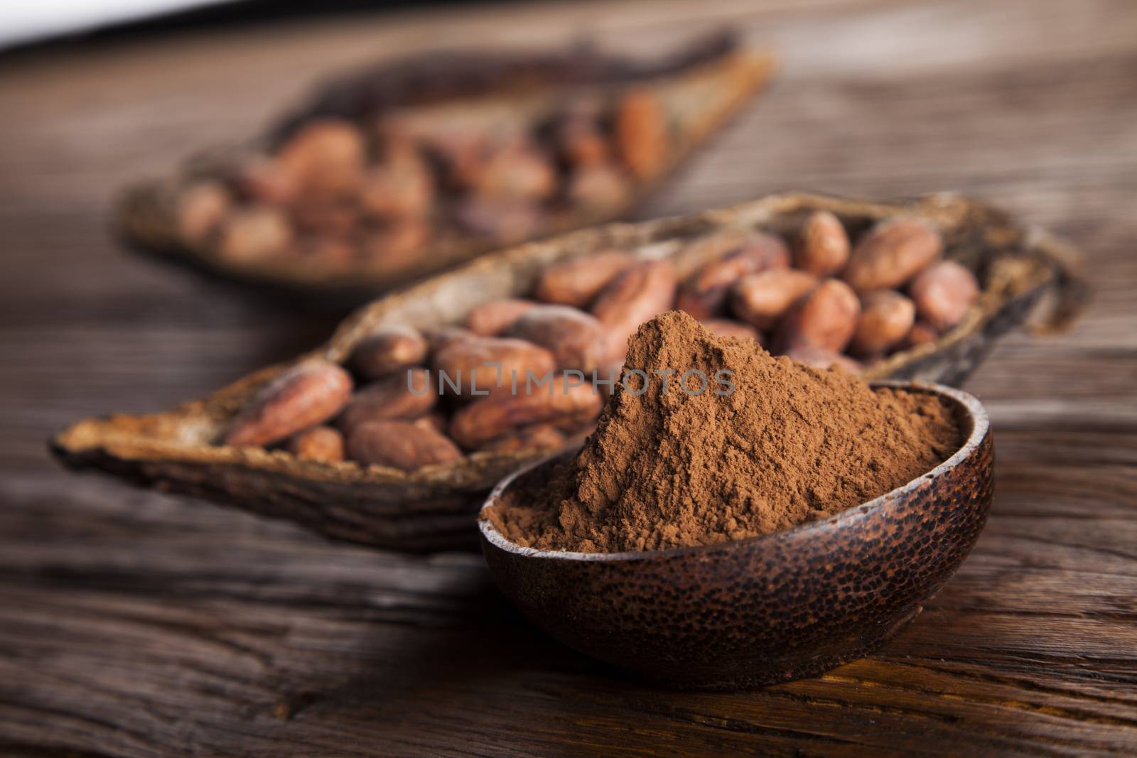 Cocoa beans in the dry cocoa pod fruit on wooden background