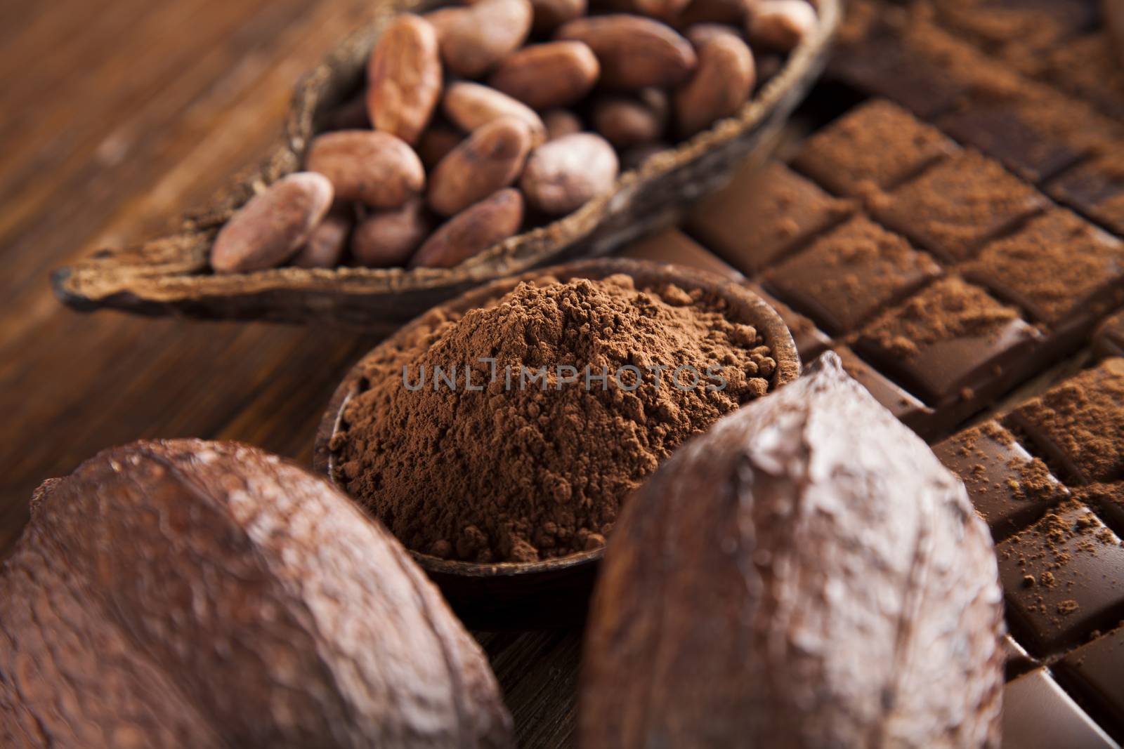 Dark homemade chocolate bars and cocoa pod on wooden