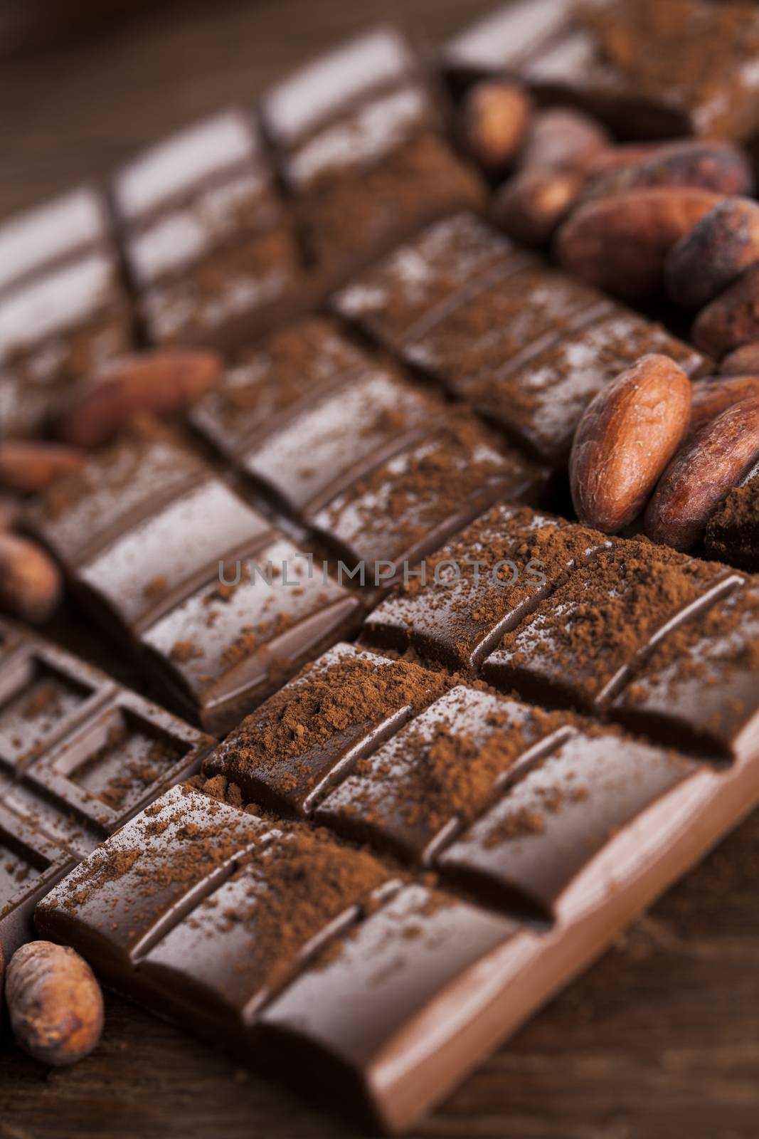 Aromatic cocoa and chocolate on wooden background