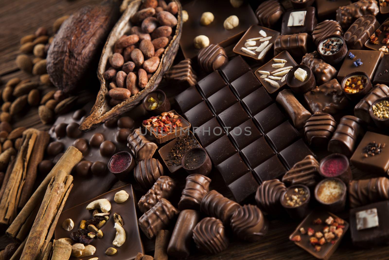 Chocolate bars and pralines on wooden background by JanPietruszka